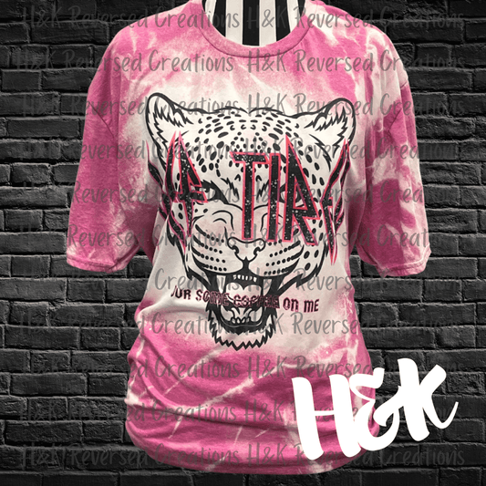 Pink short sleeve, bleached white with a leopard printed on the front that reads Def Tired, pour some coffee on me.